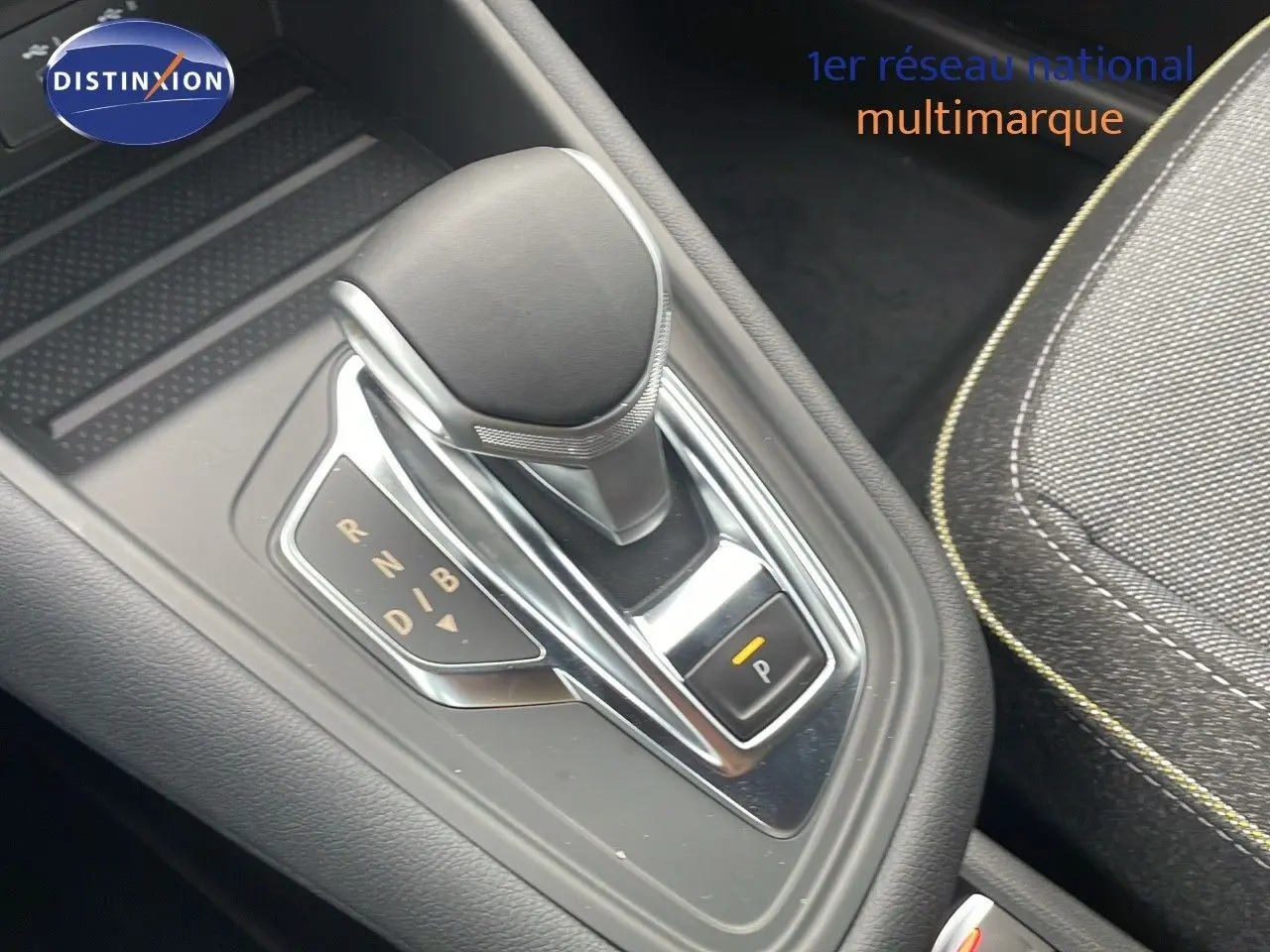 Le levier de vitesses automatique du Renault Captur E-Tech Hybrid 2025, avec sellerie tissu gris et surpiqûres jaunes.