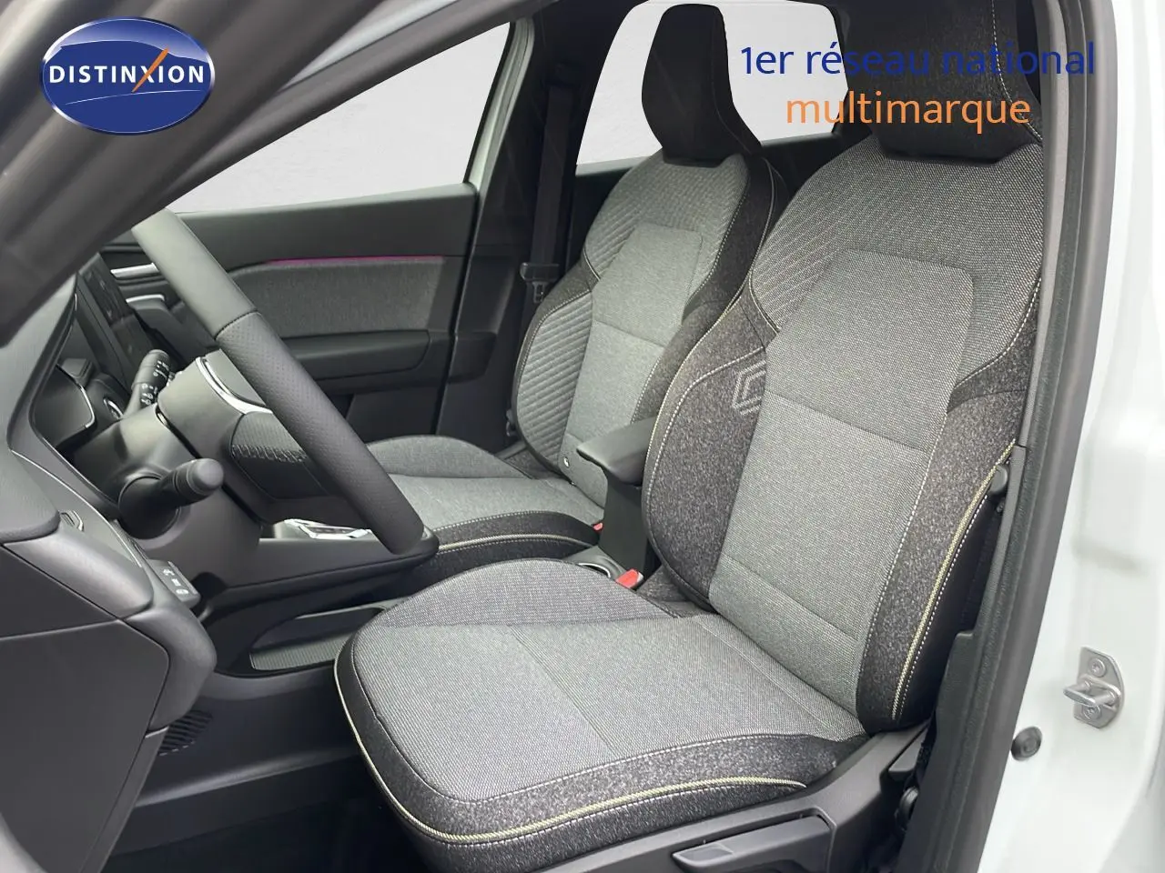 Vue intérieure côté conducteur du Renault Captur E-Tech hybride 2025, sièges tissu gris avec surpiqûres jaunes.