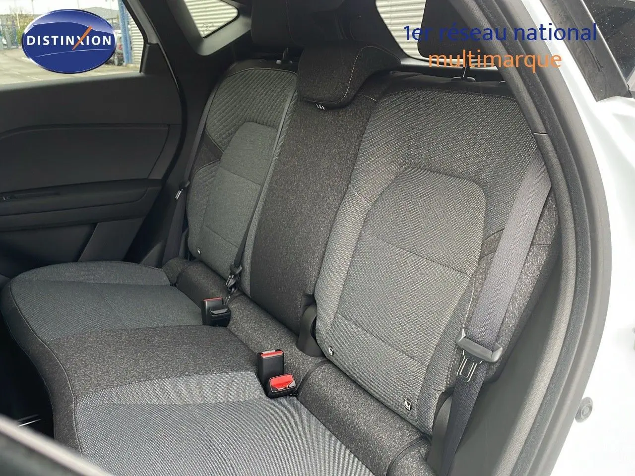 Vue du siège arrière droit en tissu gris du Renault Captur E-Tech hybride blanc nacré avec porte ouverte.