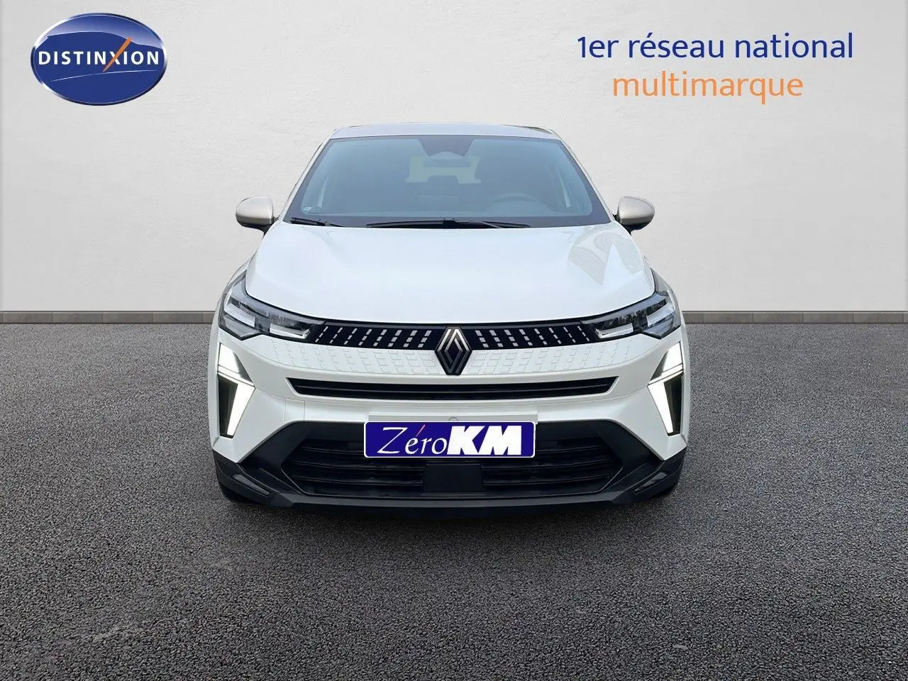 Vue frontale d'un Renault Captur E-Tech hybride blanc nacré avec toit beige, feux LED allumés sur fond neutre.