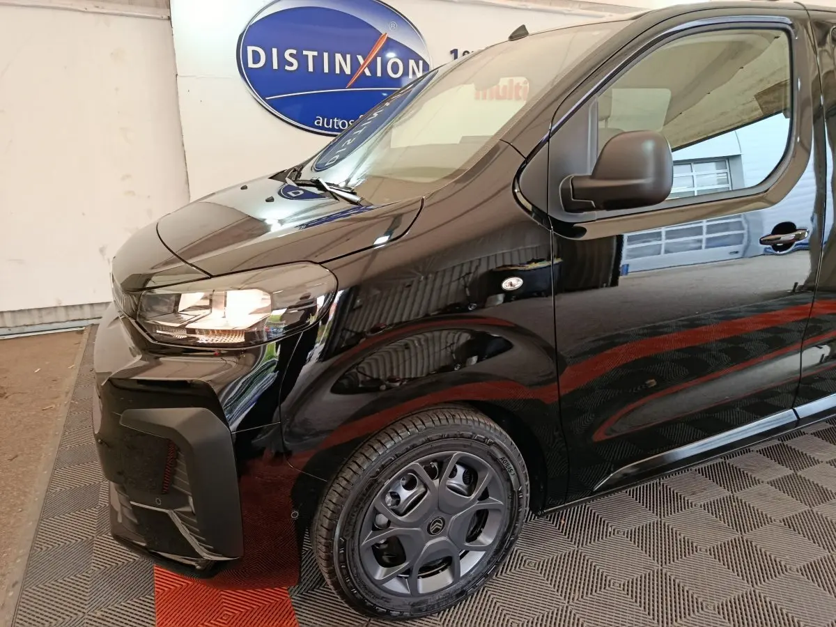 Vue 3/4 avant droit du Citroën Jumpy XL noir, mettant en valeur le phare allumé et la jante spécifique.