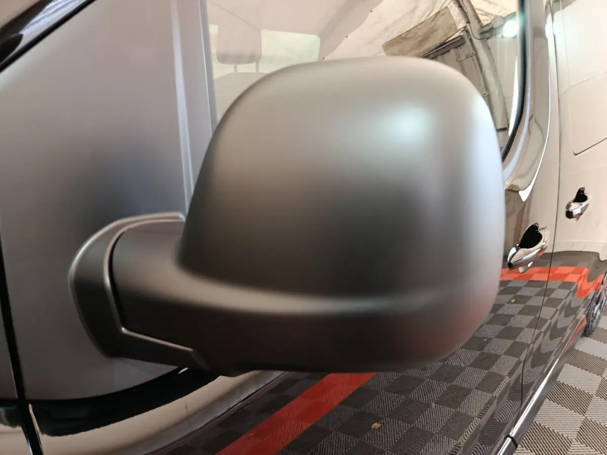 Rétroviseur côté gauche noir mat en gros plan sur Citroën Jumpy XL 2025 avec portières brillantes visibles en arrière-plan.