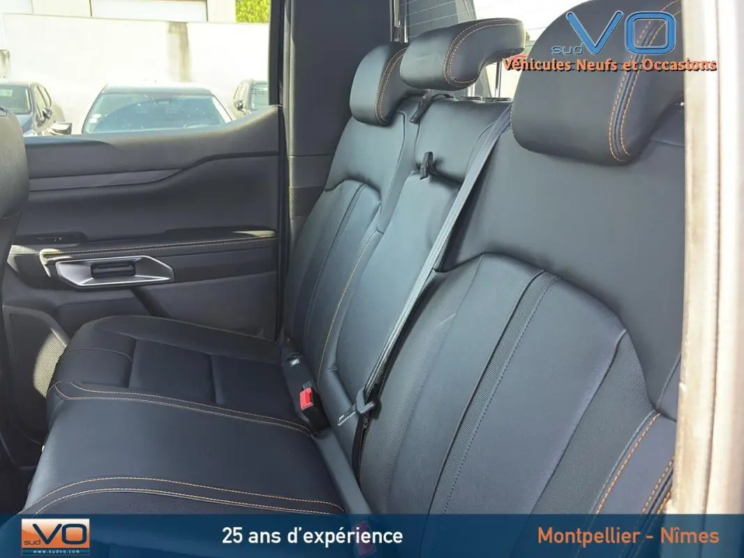 Vue intérieure sur la banquette arrière en cuir noir avec surpiqûres orange du Ford Ranger Wildtrak 2025.