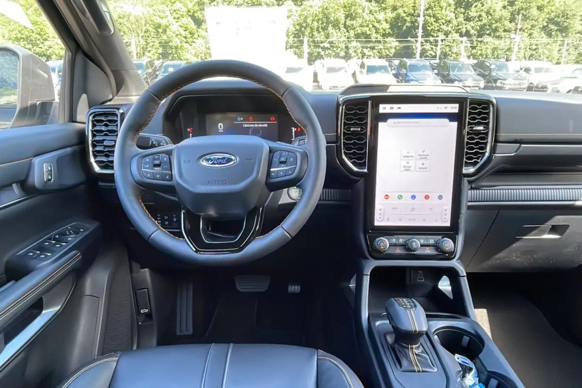Vue intérieure avant du Ford Ranger 2026 gris carbone, volant cuir multifonctions et grand écran tactile vertical.