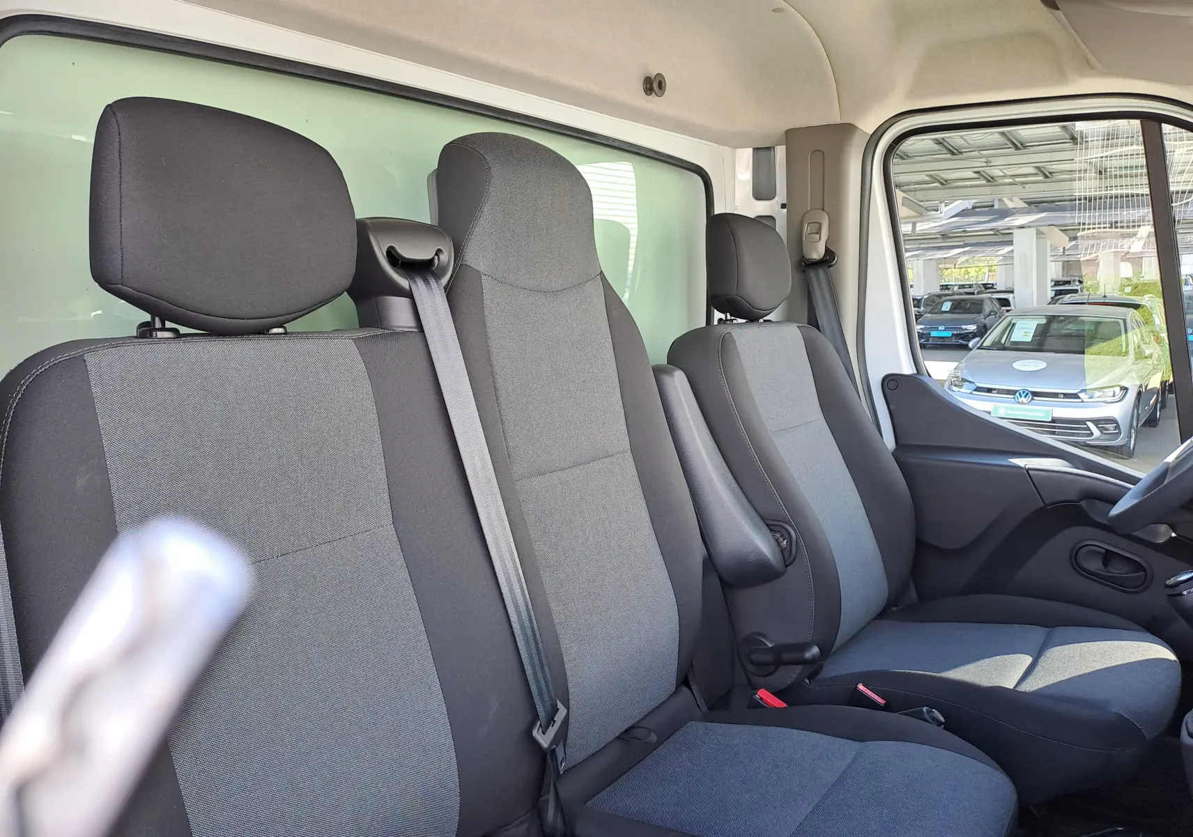 Vue intérieure côté droit montrant les sièges avant gris et noirs du Nissan Interstar Châssis Cabine blanc 2024.
