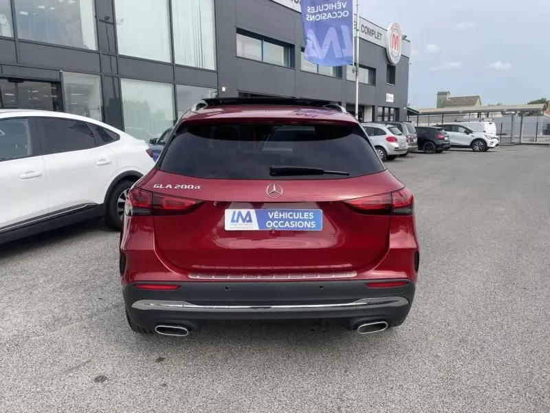 Vue arrière d'un Mercedes GLA 200 d AMG-Line rouge métal 2022 avec double sortie d'échappement et vitres teintées.