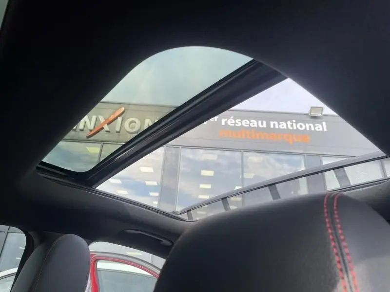 Vue intérieure du toit ouvrant panoramique du Mercedes GLA 200 D AMG-LINE rouge métal, avec surpiqûres rouges sur les sièges.