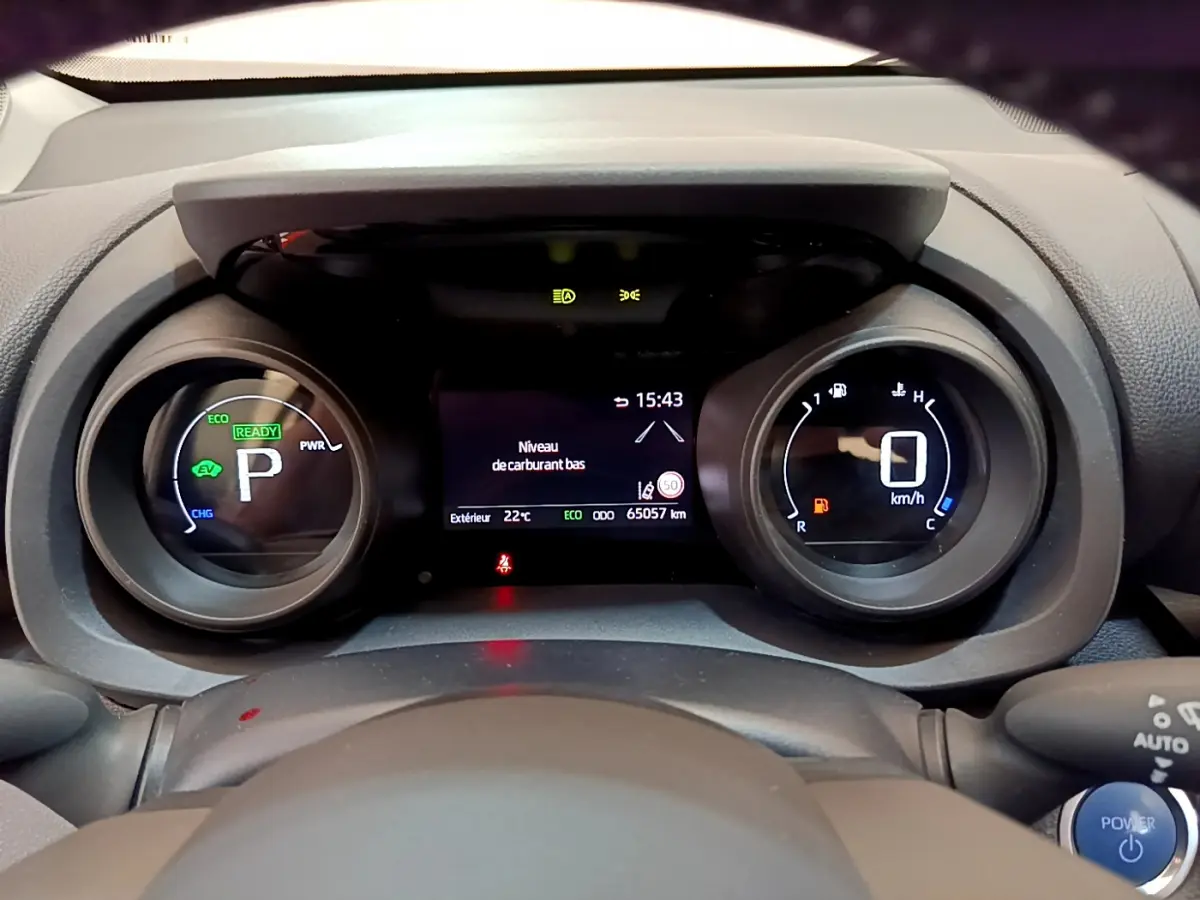 Vue rapprochée du combiné d'instruments numérique de la Toyota Yaris Cross hybride, affichant la vitesse et alertes.