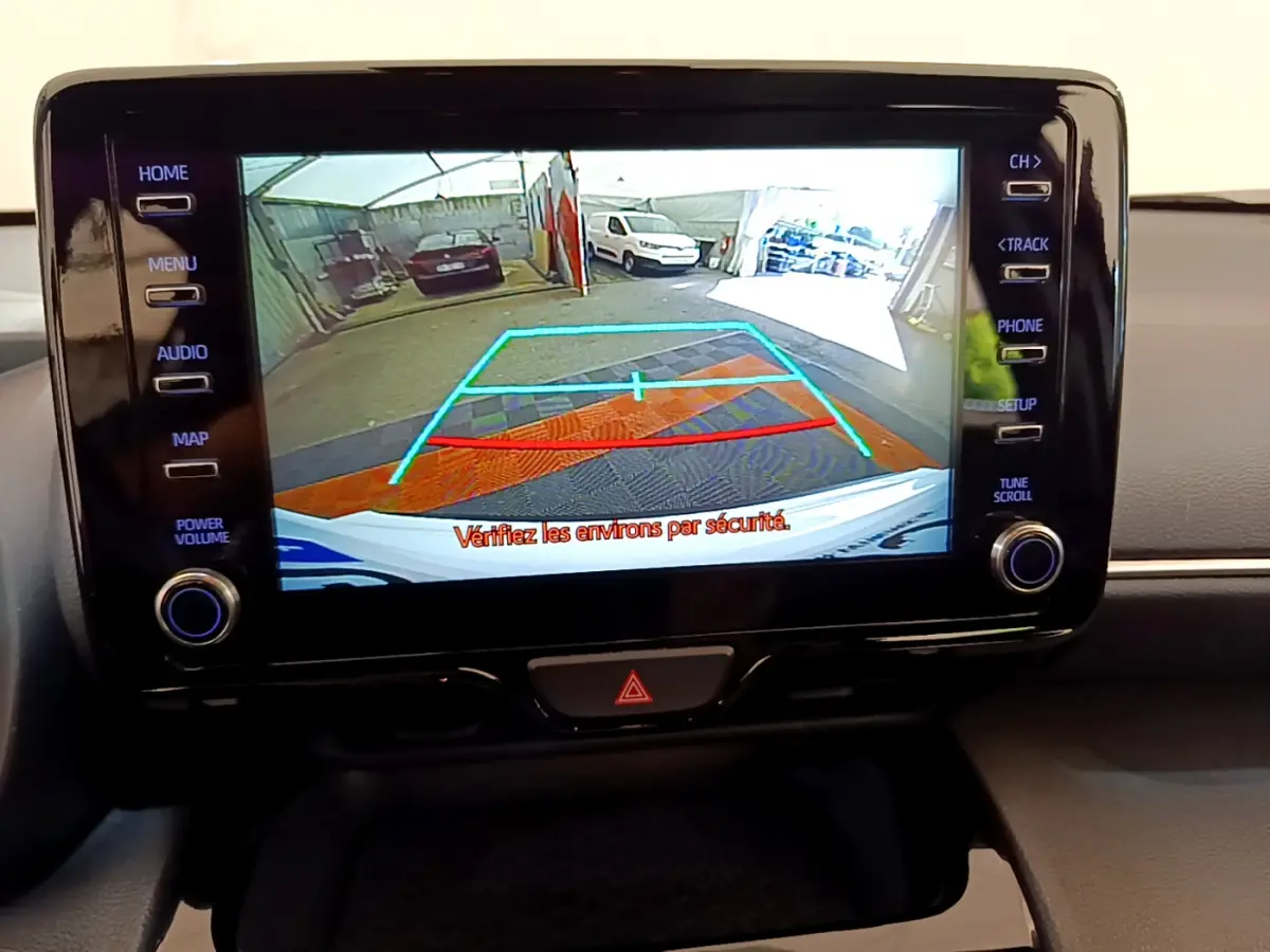 Écran tactile central affichant la caméra de recul du Toyota Yaris Cross blanc, avec guidage de stationnement coloré.