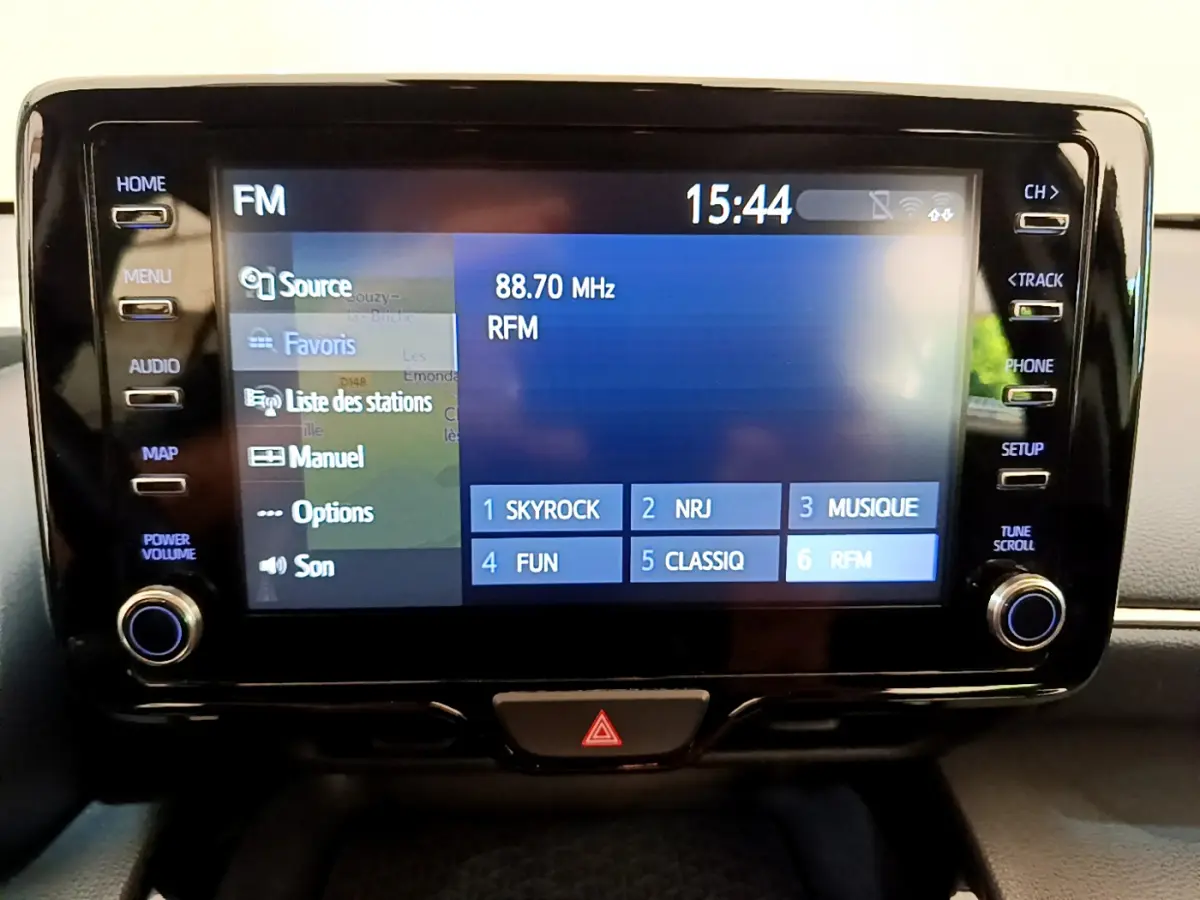 Écran tactile central affichant la radio FM avec stations présélectionnées dans une Toyota Yaris Cross blanche 2022.