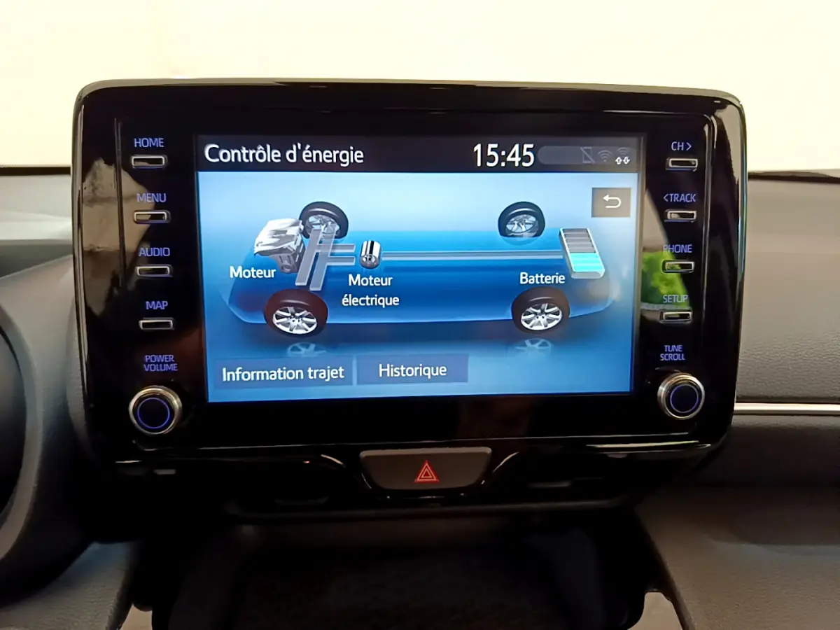 Écran tactile central du tableau de bord de la Toyota Yaris Cross blanc affichant le contrôle d'énergie hybride.