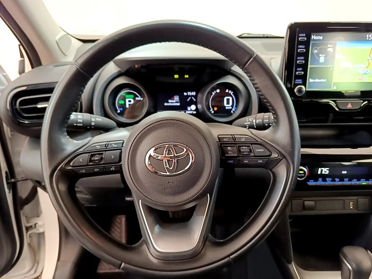 Vue centrée sur le volant cuir noir et tableau de bord numérique de la Toyota Yaris Cross blanche 2022 hybride