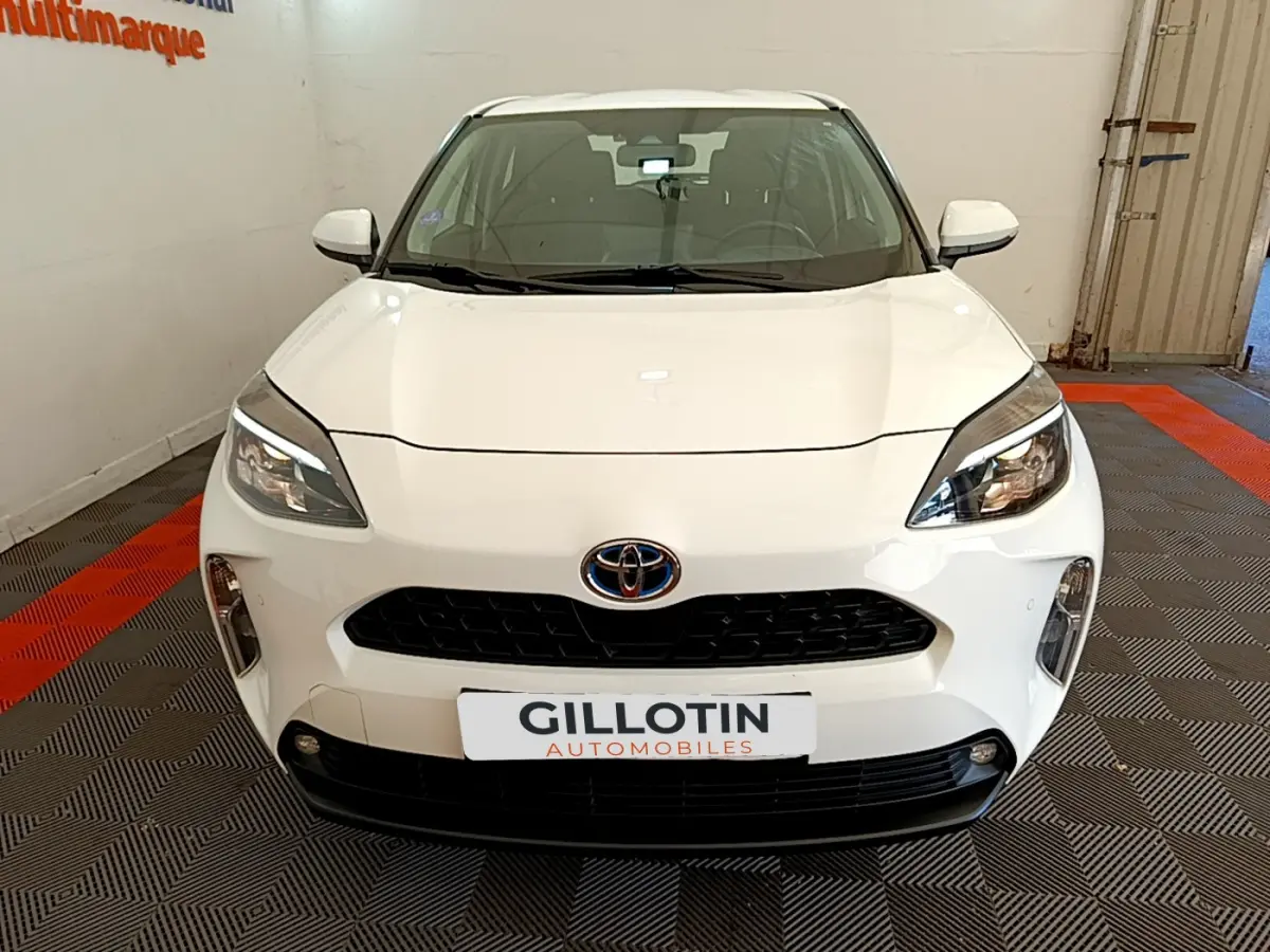 Vue frontale d'une Toyota Yaris Cross blanche 2022 avec calandre noire et phares LED distinctifs.