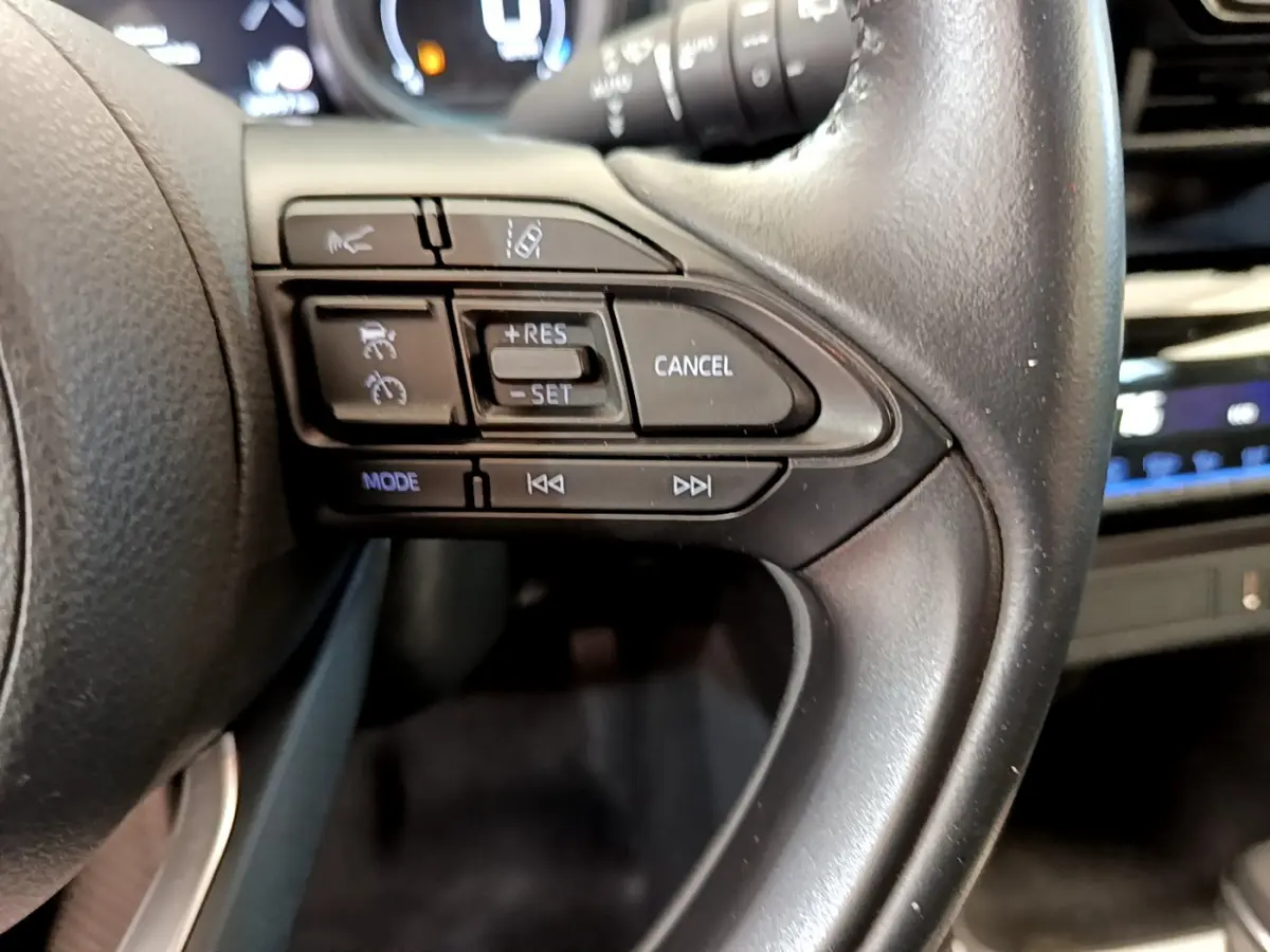 Gros plan sur les commandes du volant cuir côté droit du Toyota Yaris Cross blanc 2022, version hybride.