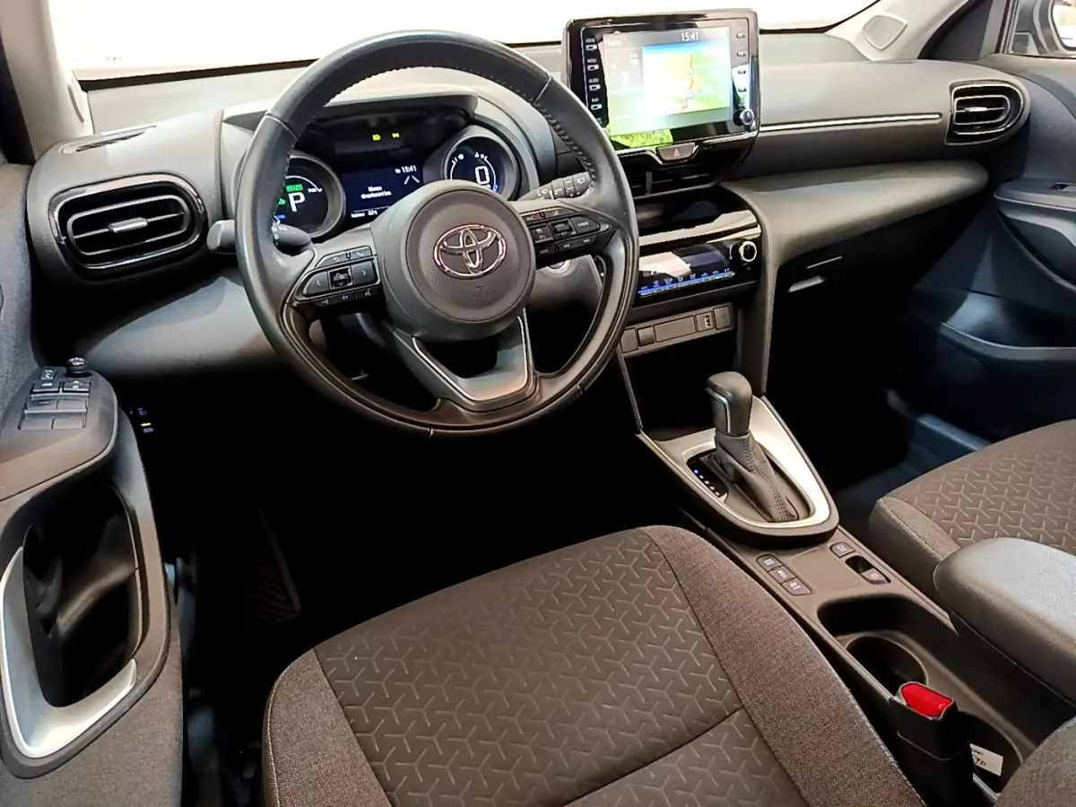 Intérieur noir et gris de la Toyota Yaris Cross 2022, vue côté conducteur sur volant cuir et écran tactile central.
