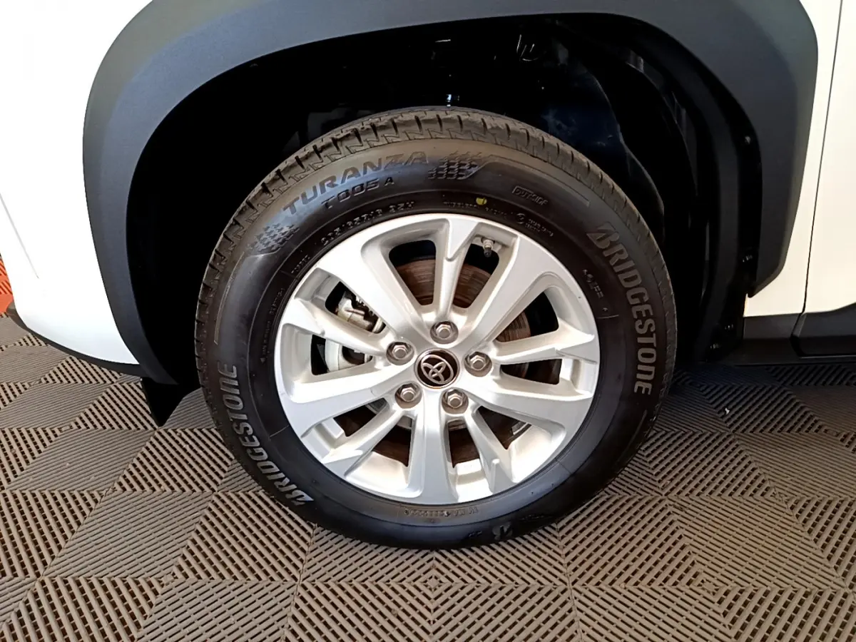Gros plan sur la roue avant gauche blanche du Toyota Yaris Cross 1.5 Hybrid avec jante alliage et pneu Bridgestone.