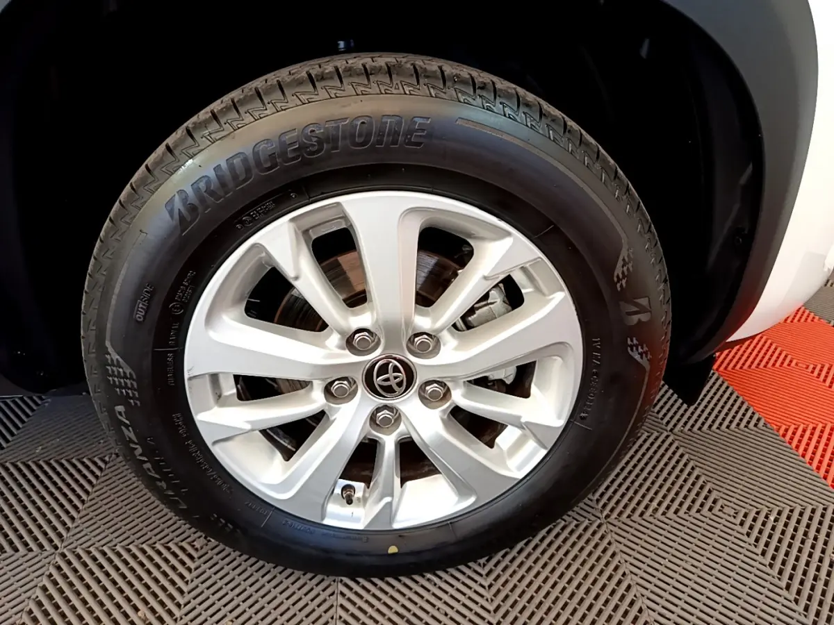 Gros plan sur la roue avant droite blanche d'une Toyota Yaris Cross 2022 avec jante alliage et pneu Bridgestone.