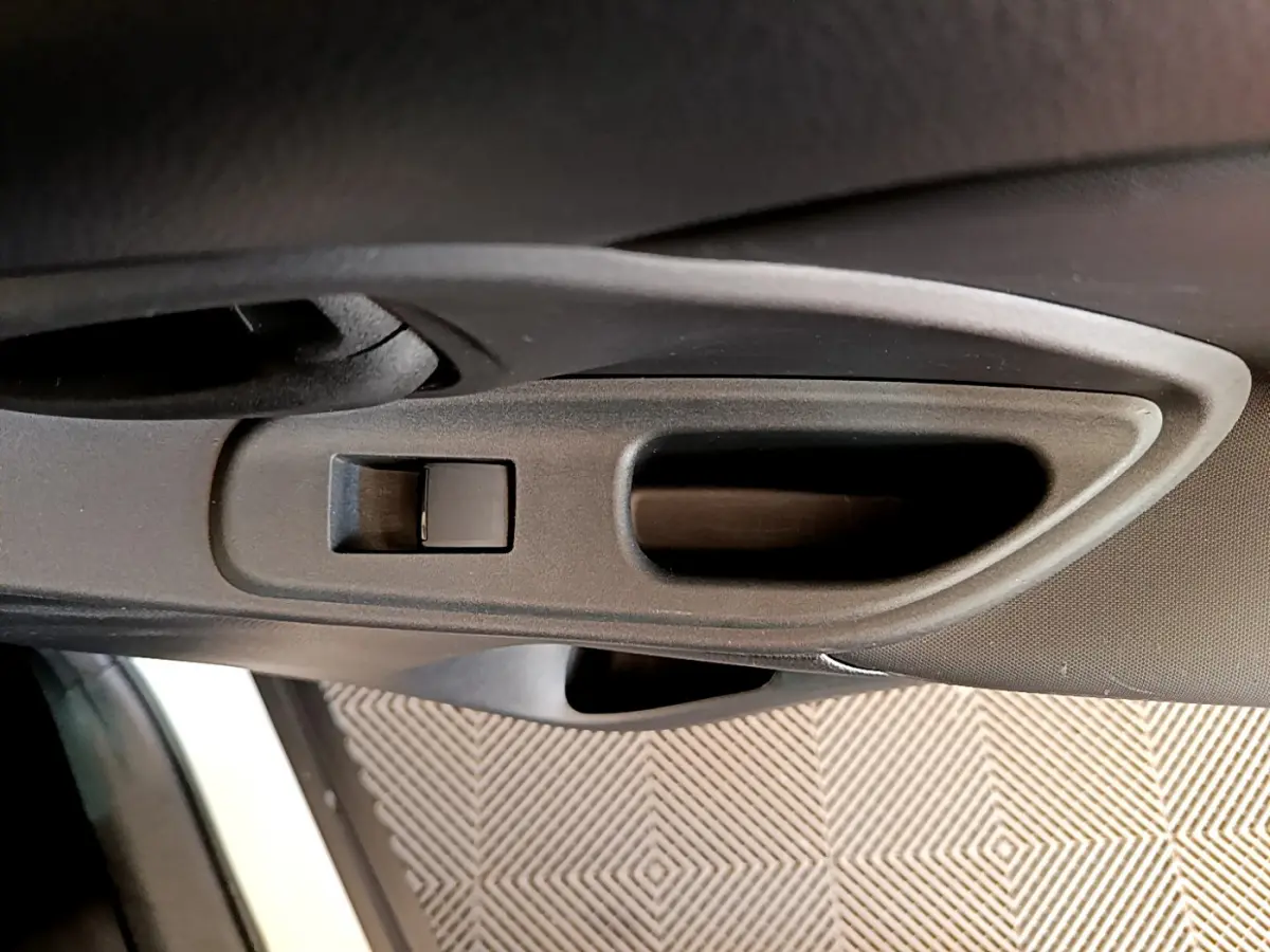 Poignée intérieure côté gauche noire de la porte d'une Toyota Yaris Cross blanche 2022, vue rapprochée.