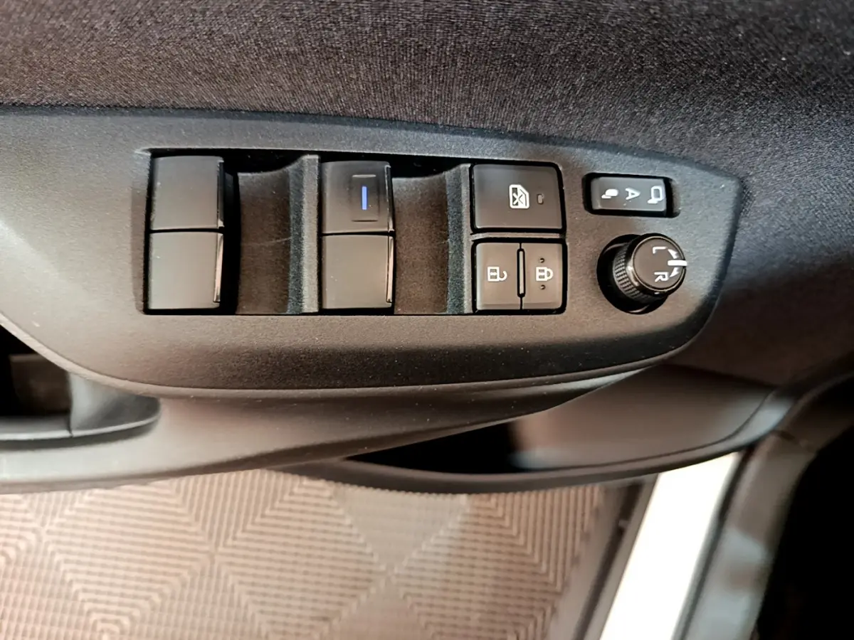 Gros plan sur les commandes de porte côté conducteur de la Toyota Yaris Cross 2022, boutons noirs sur panneau gris.