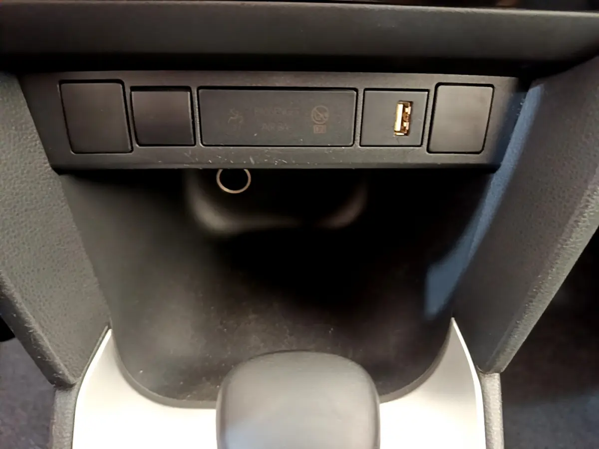 Gros plan sur la console centrale noire de la Toyota Yaris Cross 1.5 Hybrid avec port USB visible.