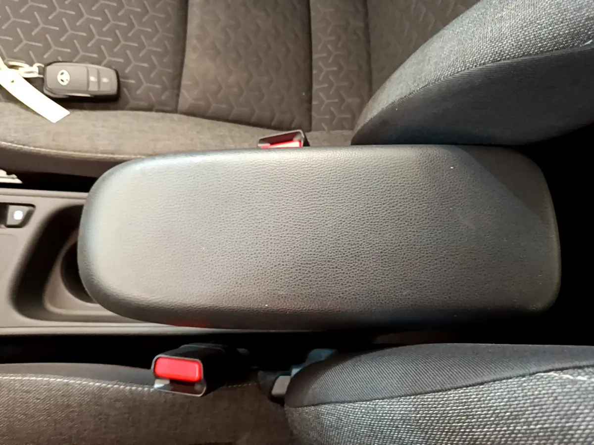 Vue rapprochée de l'accoudoir central noir et des sièges gris foncé de la Toyota Yaris Cross 2022 hybride.