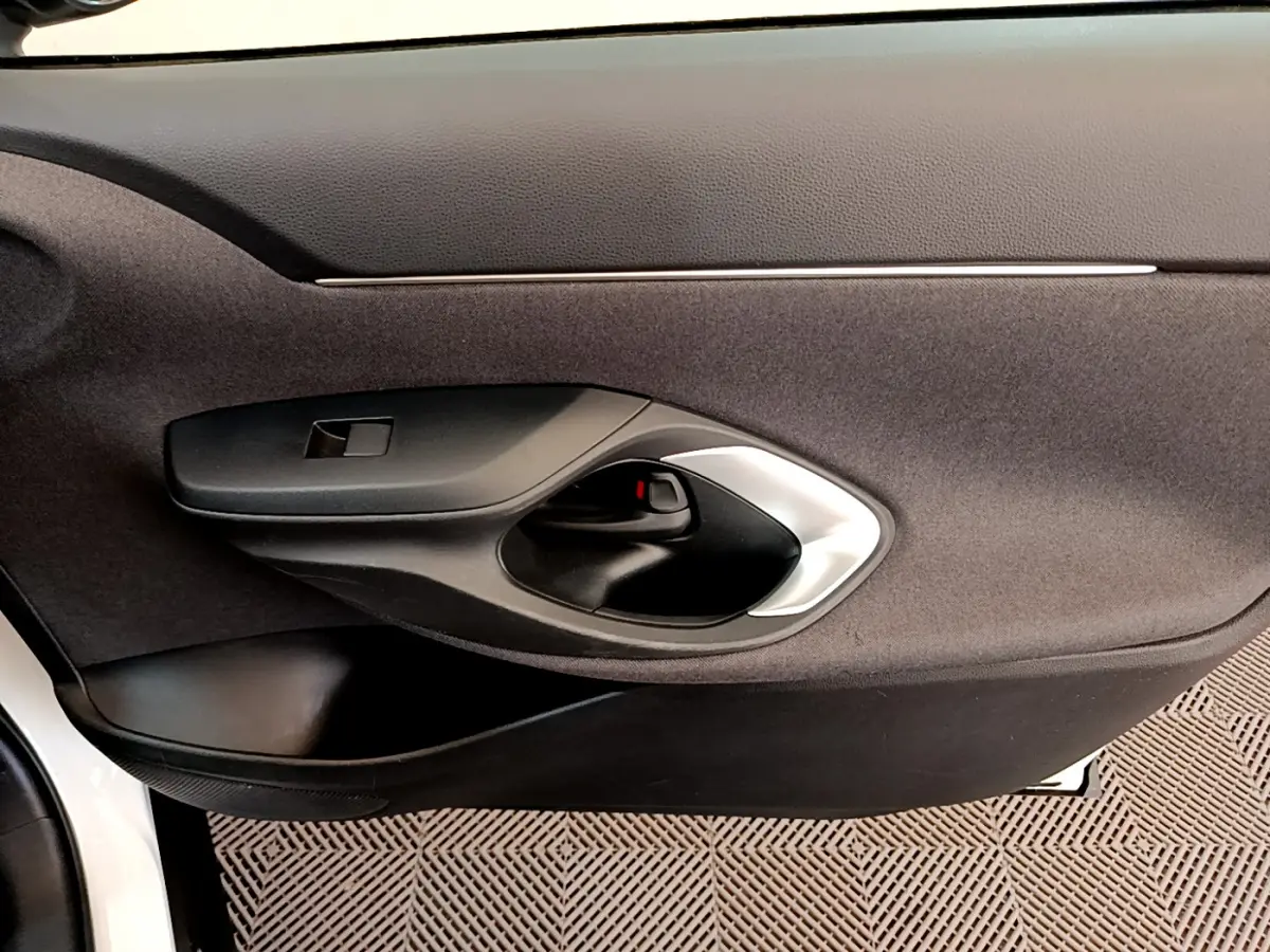 Poignée intérieure de porte côté gauche en plastique noir et argent sur Toyota Yaris Cross blanc 2022.