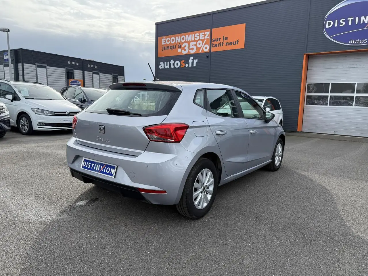 Vue 3/4 arrière droite d'une SEAT Ibiza 2022 argent Urban avec jantes alliage 15 pouces sur parking extérieur.