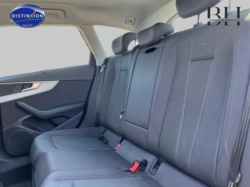 Vue intérieure de la banquette arrière noire de l'Audi A4 Avant 30 TDI, côté gauche avec appuie-têtes et ceintures visibles.