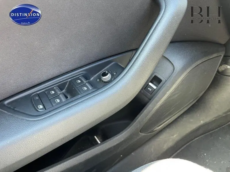 Détail de la porte avant gauche de l'Audi A4 Avant bleu, montrant les commandes des vitres et rétroviseurs.