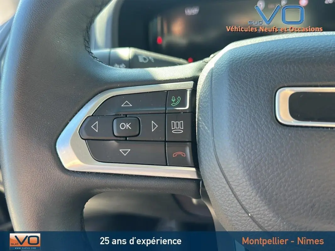 Gros plan sur les commandes gauche du volant noir du Jeep Renegade 2024 avec boutons multifonctions et finition chrome.