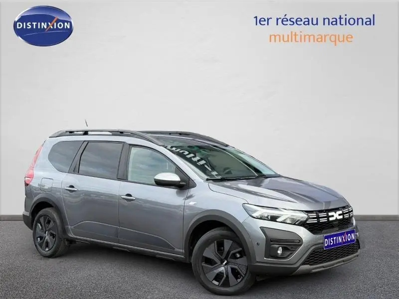Vue 3/4 avant droite d'un Dacia Jogger gris 2025 avec toit noir et jantes noires distinctives.