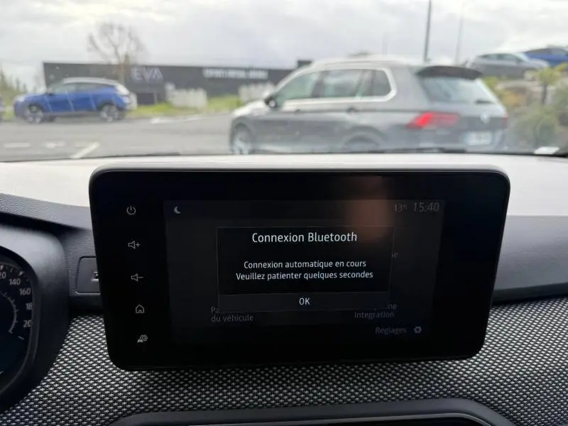 Vue intérieure du tableau de bord du Dacia Jogger 2025, écran central affichant une connexion Bluetooth en cours.