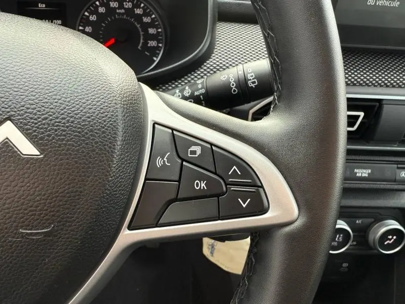 Gros plan sur le volant du Dacia Jogger gris 2025, montrant les commandes multifonctions côté gauche.