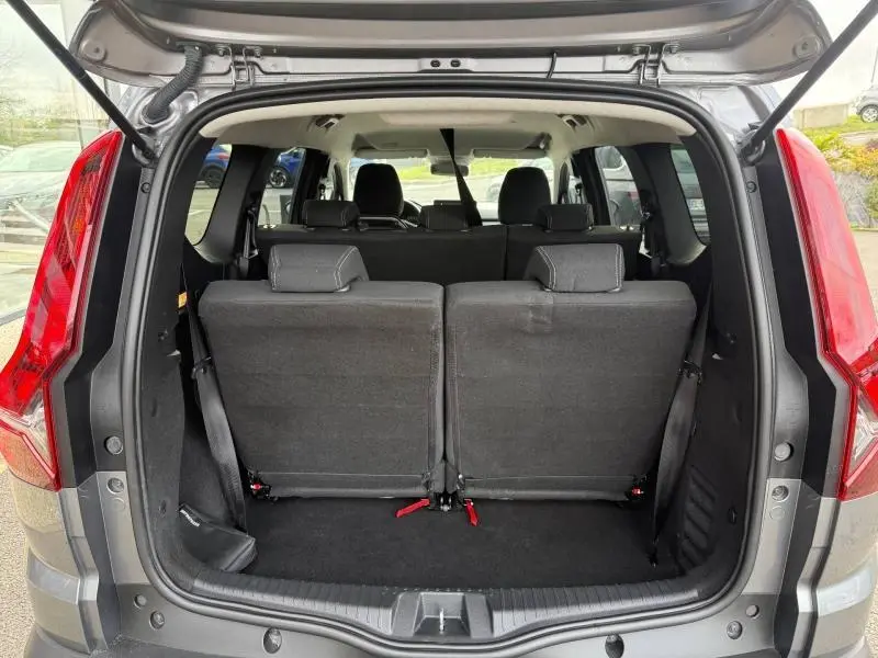 Vue arrière du coffre ouvert d'un Dacia Jogger gris 2025, montrant les sièges arrière relevés et l'habitacle intérieur.