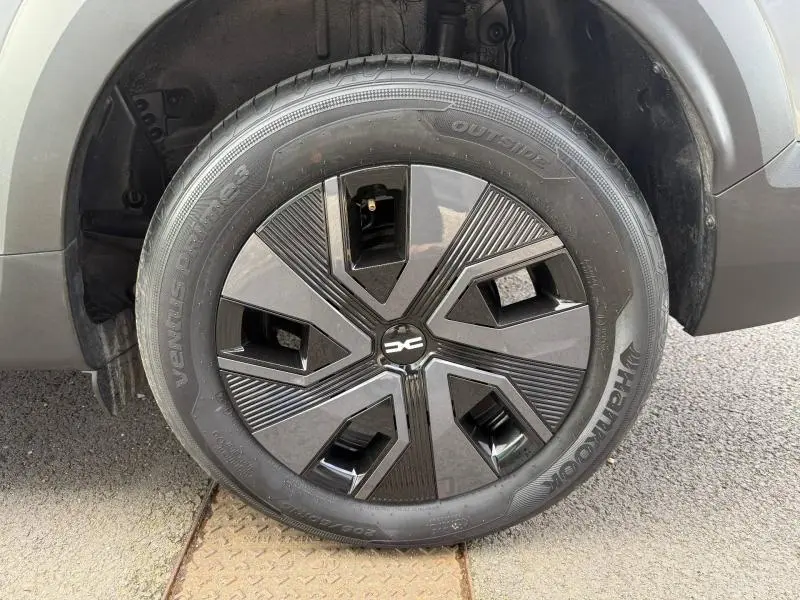 Gros plan sur la roue avant gauche grise du Dacia Jogger 2025 avec jante noire au design géométrique distinctif.
