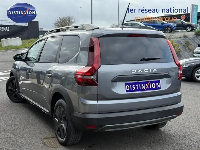 Vue 3/4 arrière droite d'un Dacia Jogger gris 2025, version Expression 7 places, avec feux arrière distinctifs en forme de L.