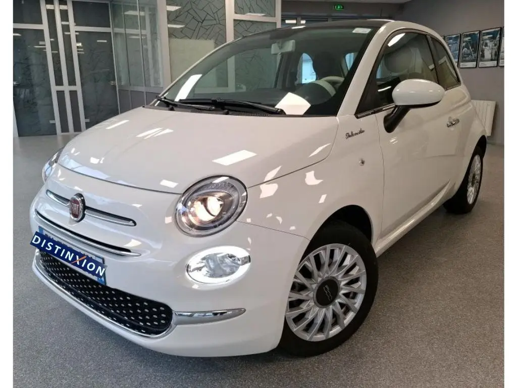 Vue 3/4 avant droite d'une Fiat 500 blanche Bossa Nova, avec phares allumés et jantes multibranches distinctives.