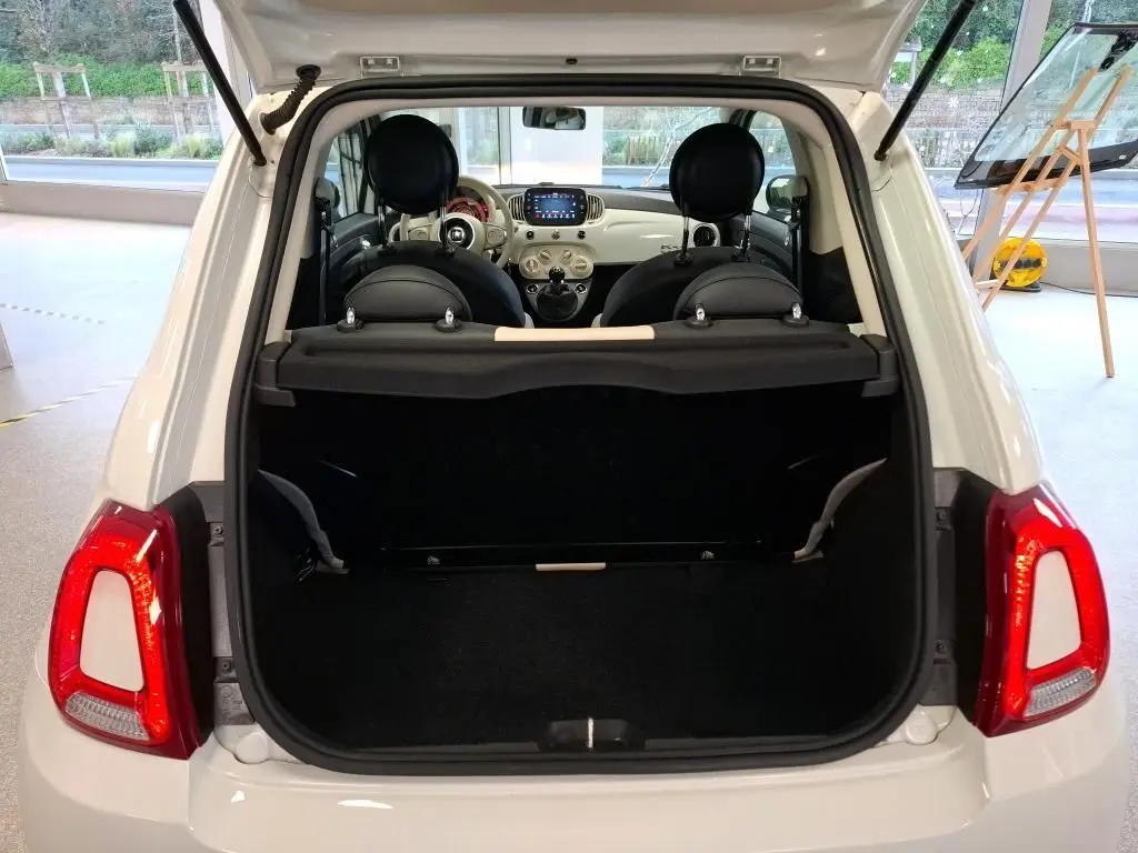 Vue arrière ouverte de la FIAT 500 blanche Bossa Nova, montrant le coffre vide et l’intérieur avec tableau de bord clair.