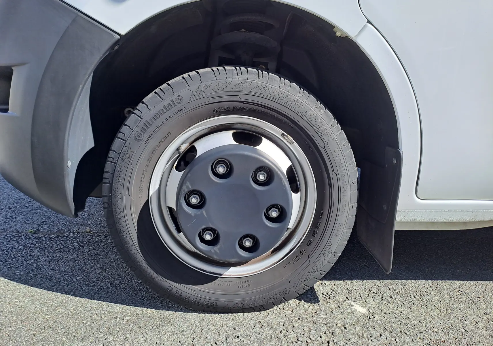 Gros plan sur la roue avant droite du Nissan Interstar blanc, mettant en valeur le pneu Continental et l'aile en plastique noir.