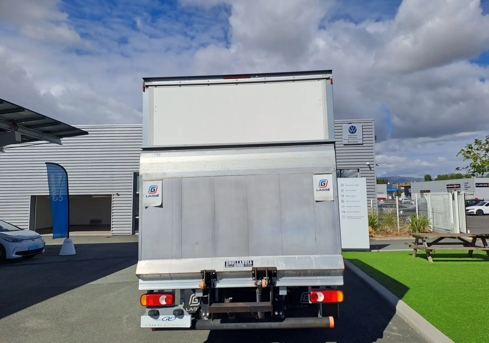 Vue arrière d’un Nissan Interstar châssis cabine blanc 2024 avec hayon élévateur et panneaux métalliques.