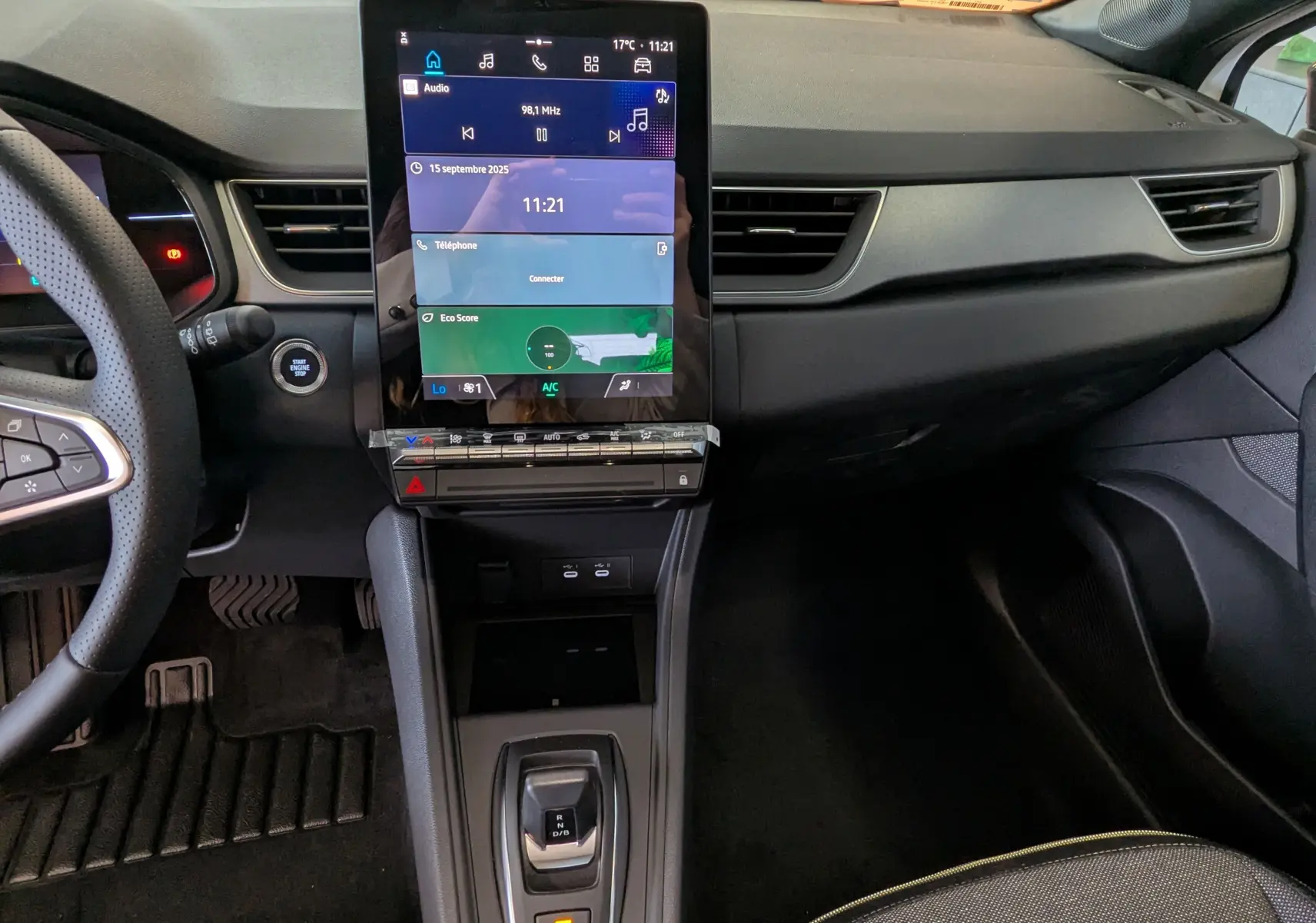 Vue intérieure du tableau de bord du Renault Captur E-Tech 2025 avec écran tactile vertical et levier de vitesses automatique.