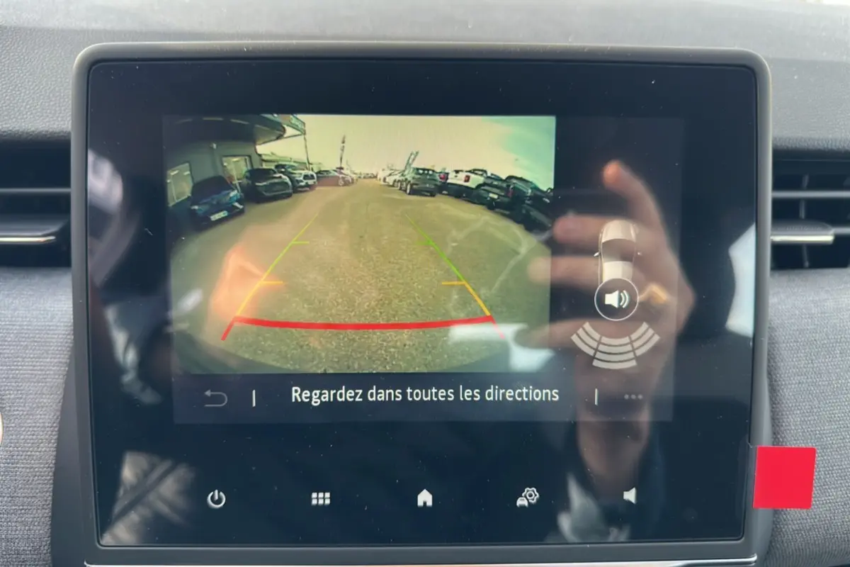 Écran de la caméra de recul de la Renault Clio gris schiste, affichant la vue arrière avec lignes de guidage colorées.