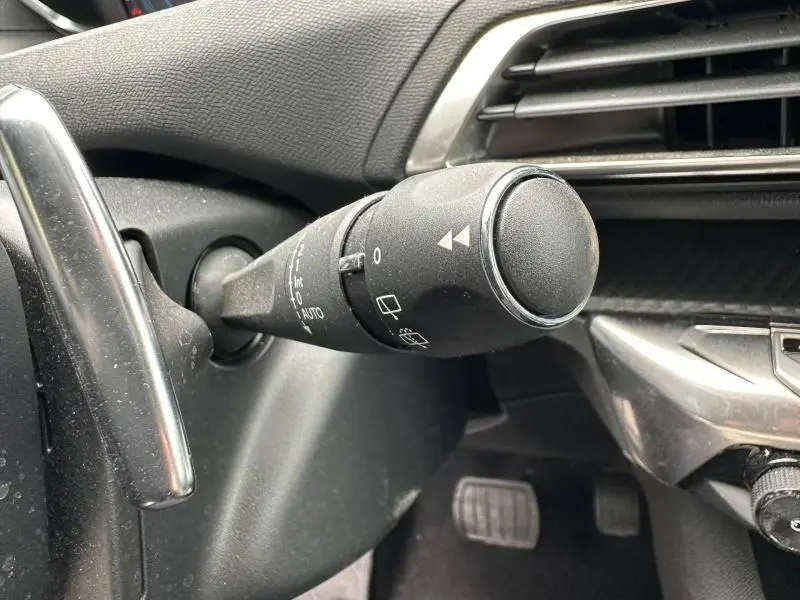 Gros plan sur la commande d’essuie-glace côté gauche du tableau de bord du Peugeot 3008 Hybride Rechargeable noir Perla Nera.