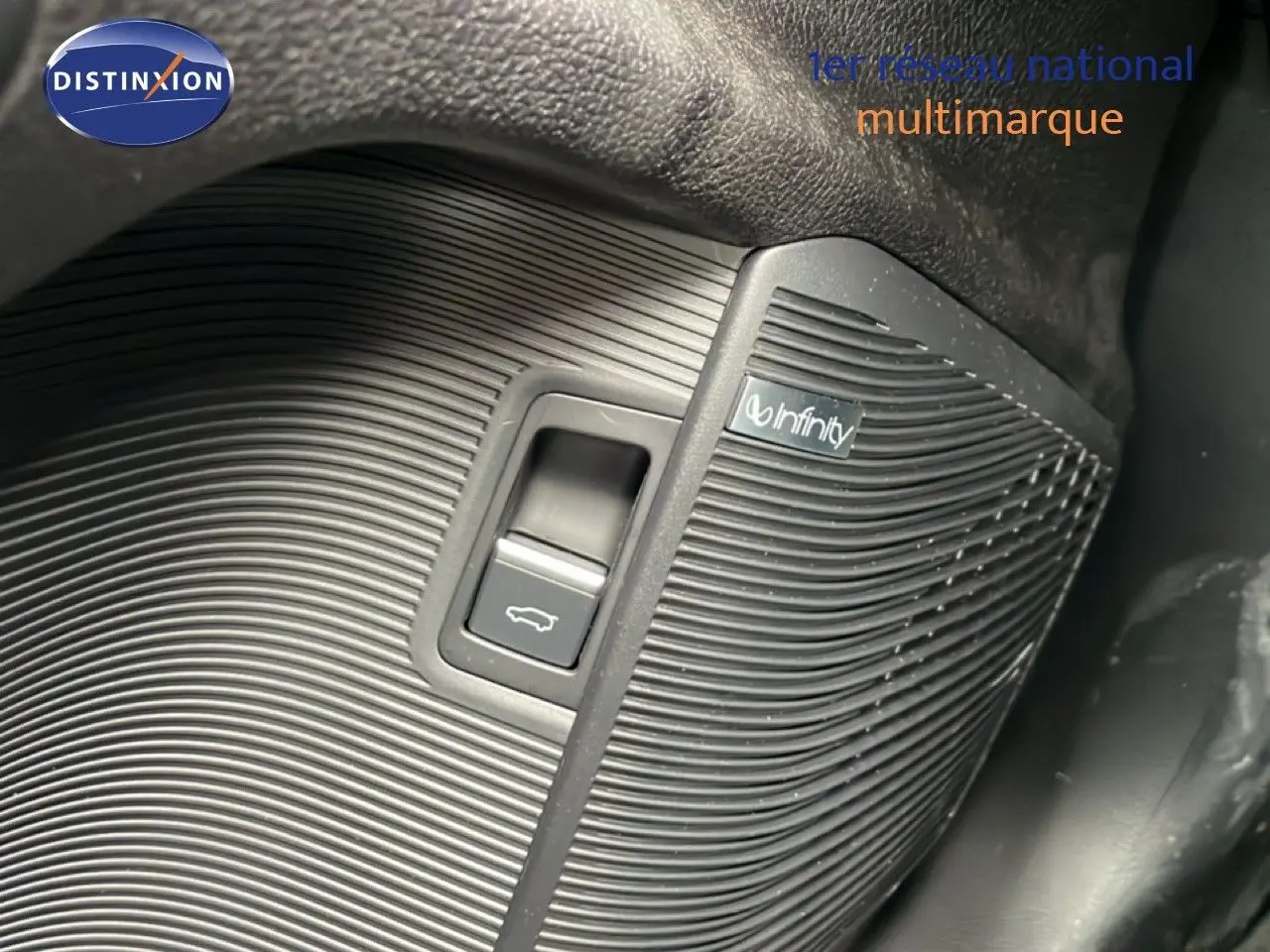 Détail du bouton d'ouverture de coffre avec haut-parleur Infinity intégré dans l'habitacle noir du BYD SEAL U.