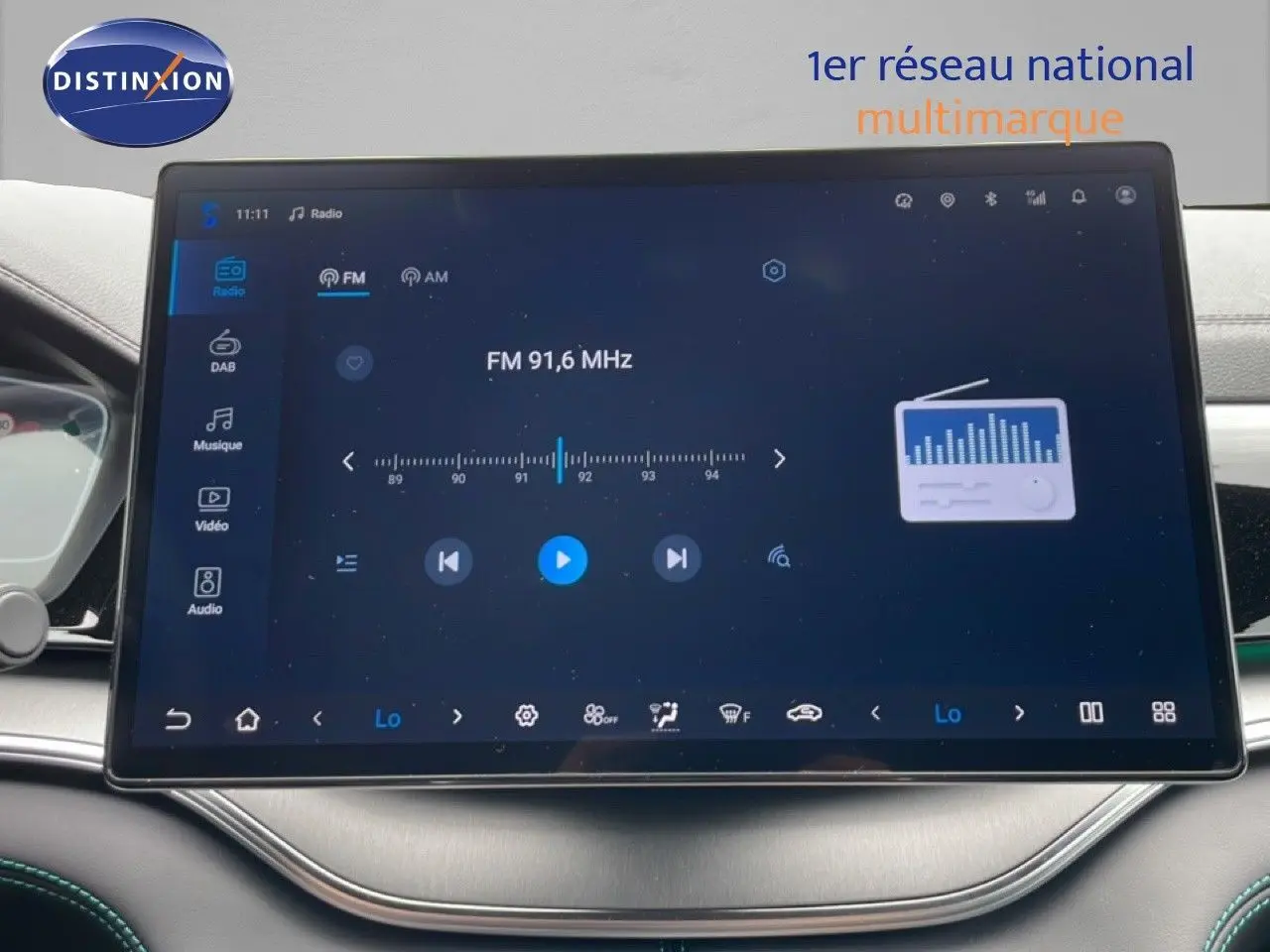 Vue intérieure centrée sur l'écran tactile du tableau de bord du BYD SEAL U gris, affichant la radio FM 91,6 MHz.