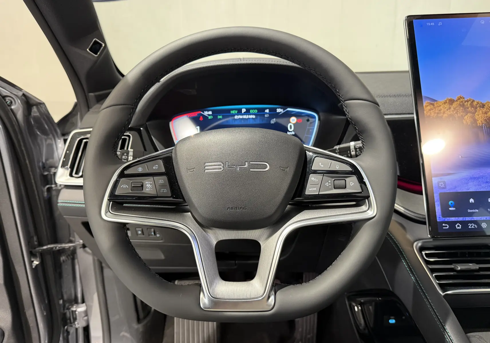 Vue rapprochée du volant noir du BYD SEAL U 2026 avec tableau de bord numérique et écran tactile latéral.