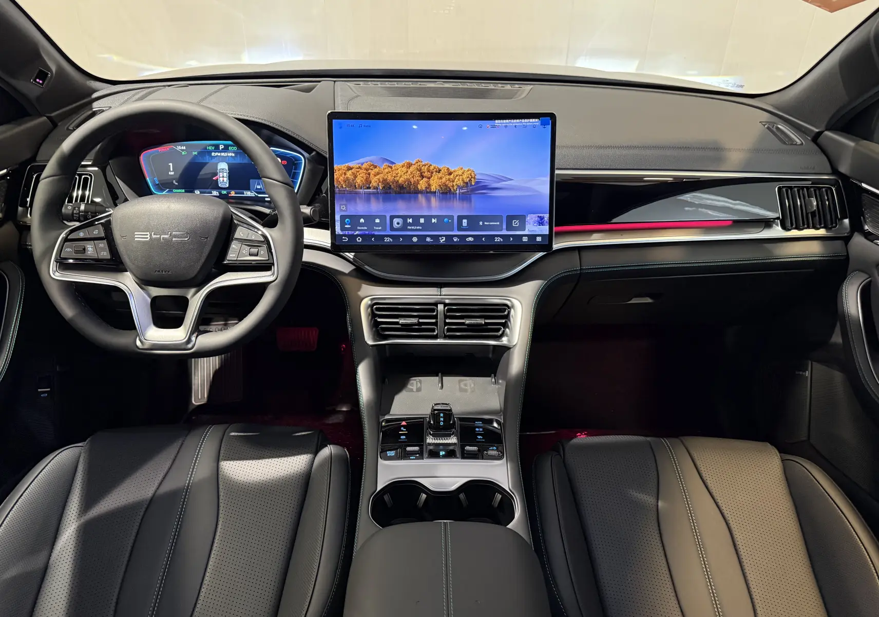 Vue intérieure avant du BYD SEAL U 2026 avec tableau de bord noir, écran tactile central et volant multifonction.