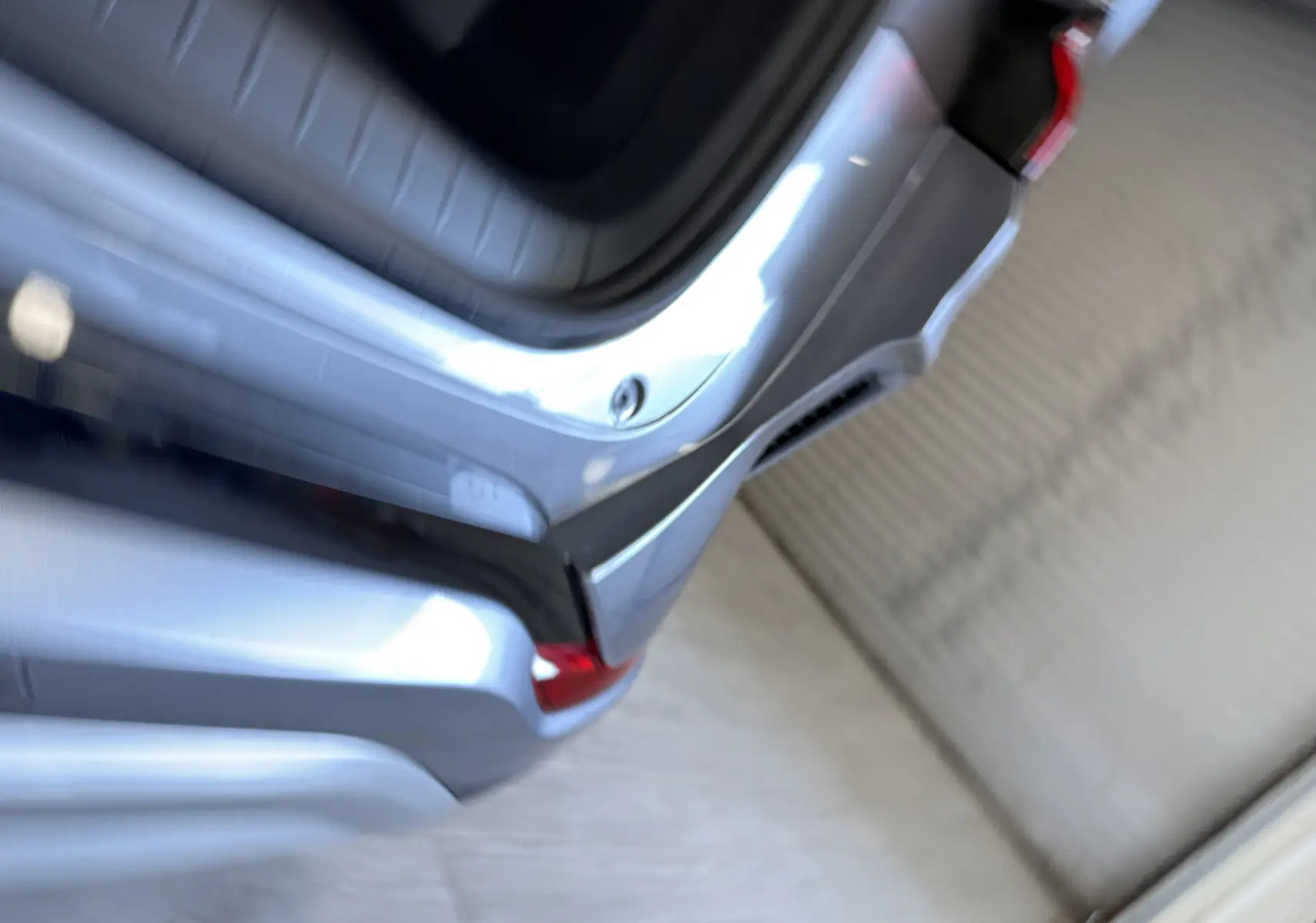 Vue rapprochée du coffre arrière ouvert du BYD SEAL U 2026 en gris métallisé avec feux arrière rouges visibles.