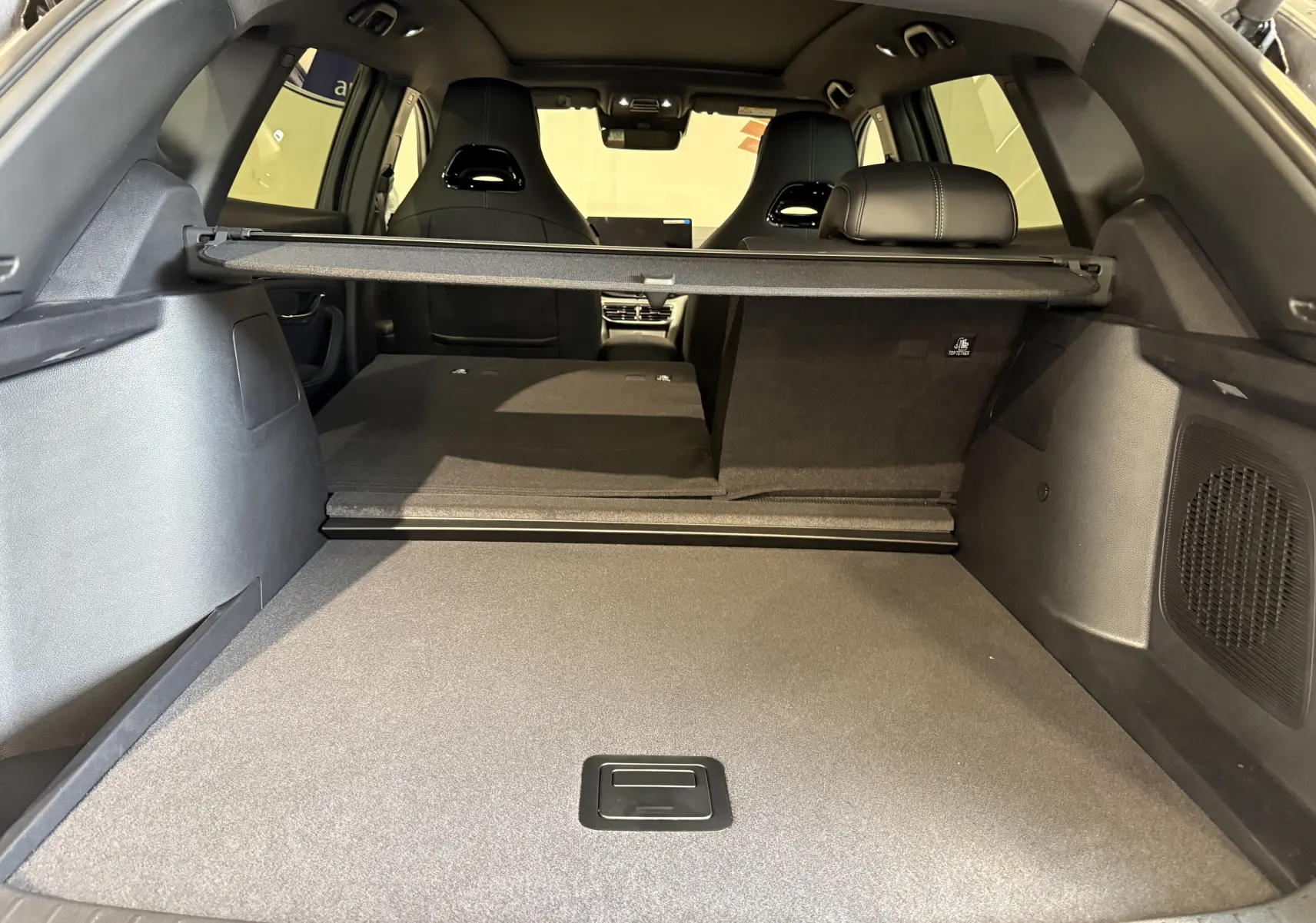 Vue depuis le coffre du BYD SEAL U 2026 gris, montrant l’espace de chargement avec banquette arrière partiellement rabattue.