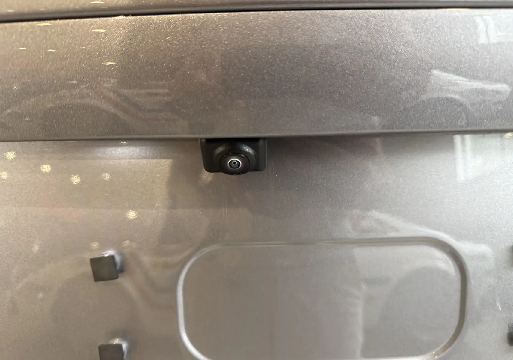 Gros plan sur la caméra de recul intégrée à la malle arrière du BYD SEAL U gris métallisé.